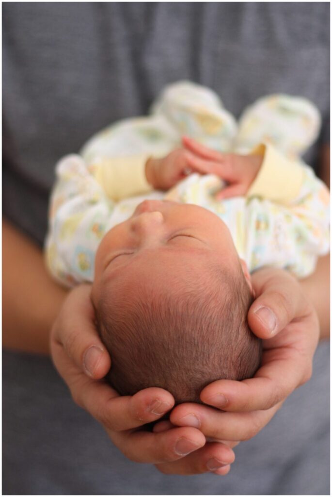 Natick dad hold newborn baby in hands photo