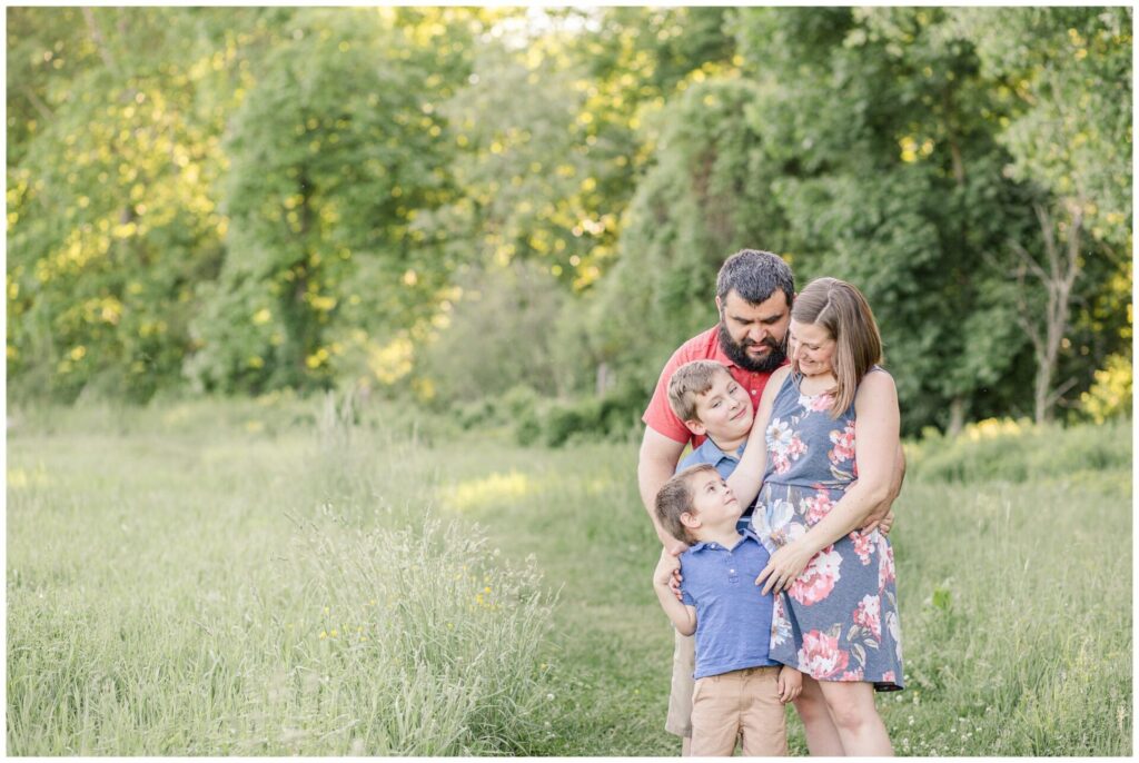 family hugs in field for lifestyle photo Needham MA