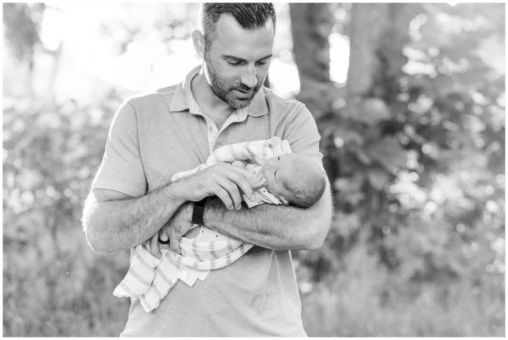 newborn holds dad finder outside for photo Sherborn MA