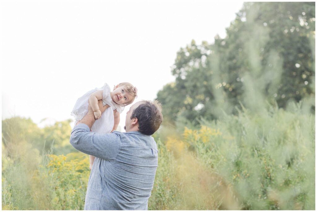 Dad holds one year old up for one year old photo session in Metro West Boston Massachusetts