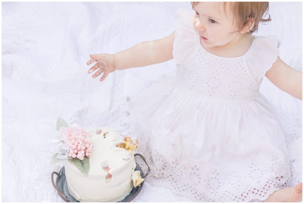 One year old smashes cake for photo session in Wellesley Massachusetts