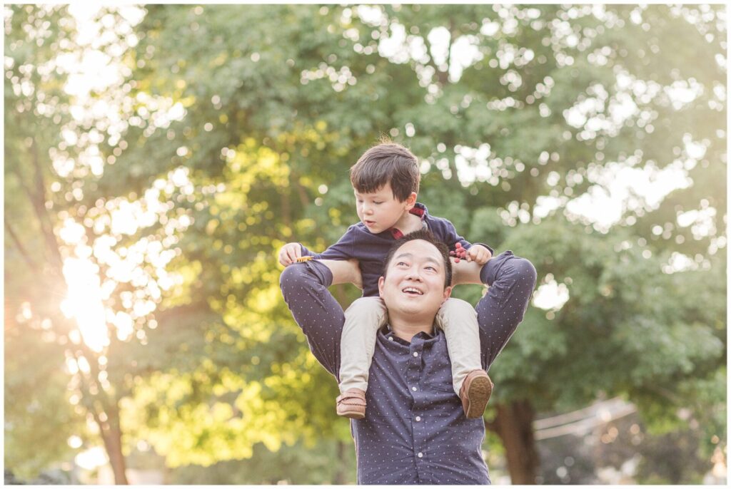 father hold son on shoulders during family photo session in Needham Massachusetts