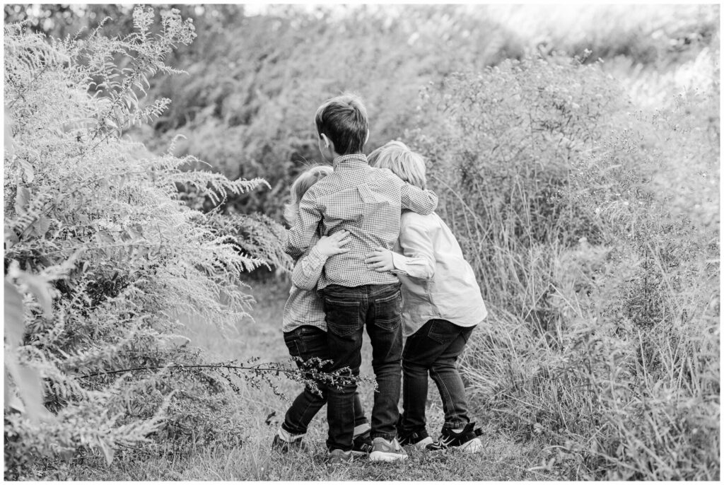 black and white photo of three brothers hugging Newton Massachusetts