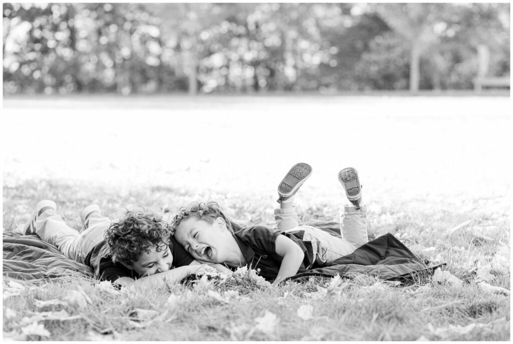 black and white photo of brother laughing together at Elm Bank Reservation Wellesley Massachusetts