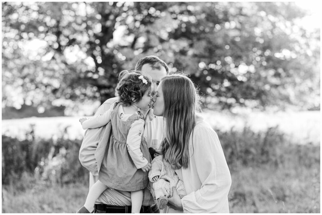 black and white photo of mom and daughter kissing during outdoor newborn photo session in Wayland Massachusetts