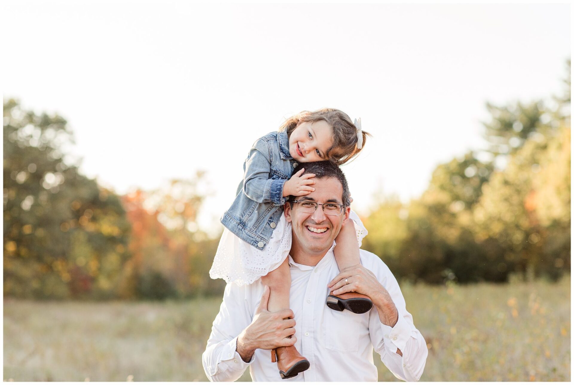 photo of Dad with daughter on his shoulders in field during Natick Massachusetts family photo session