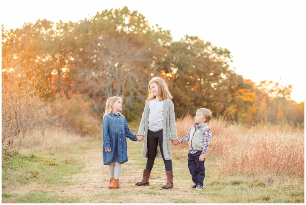 Kids hold hands in Wayland Massachusetts field during family photo session