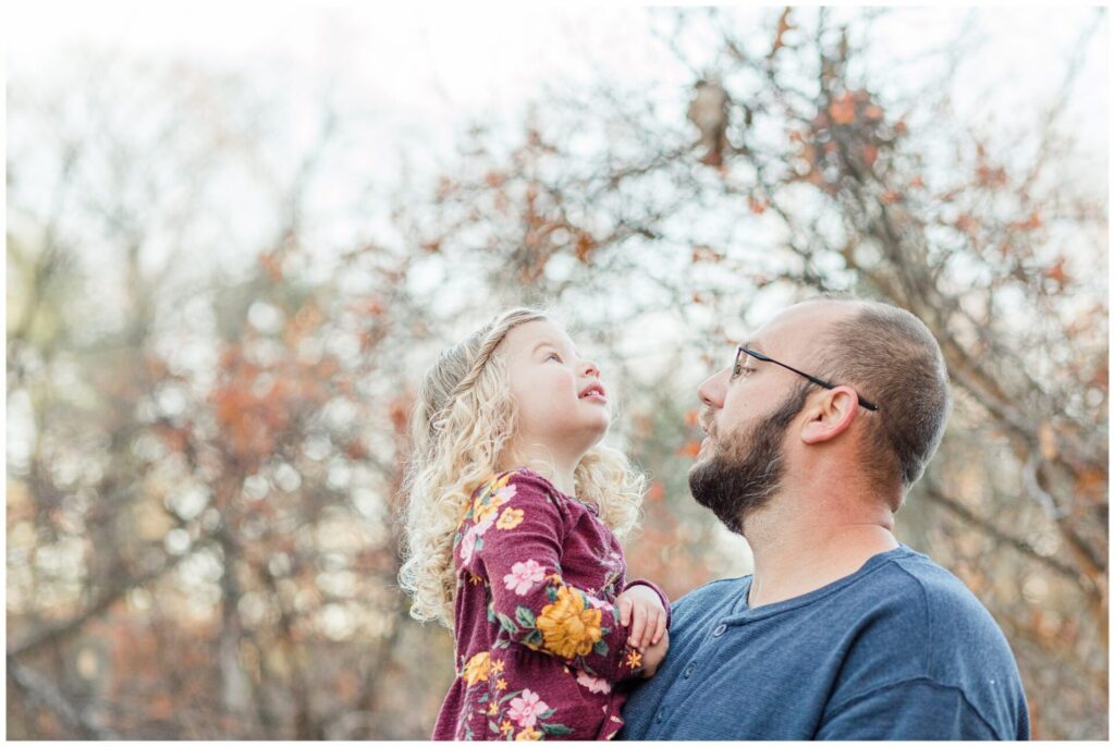 dad holds toddler daughter during cold weather family photo session in Natick Massachusetts