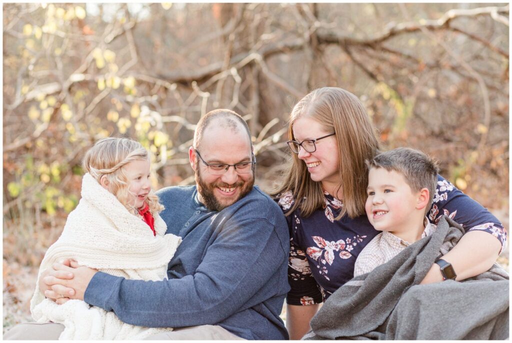 family cuddling with blankets for family photo session in Natick Massachusetts
