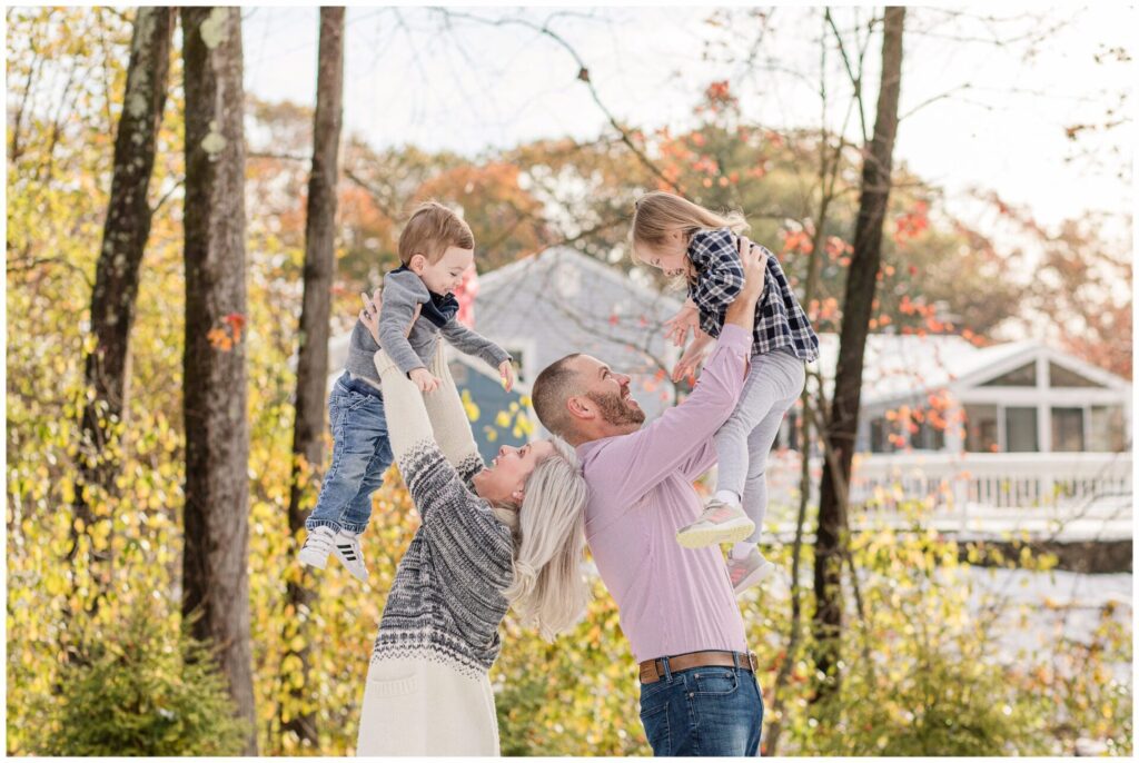 parents hold kids above their heads for family photo session Natick Massachusetts