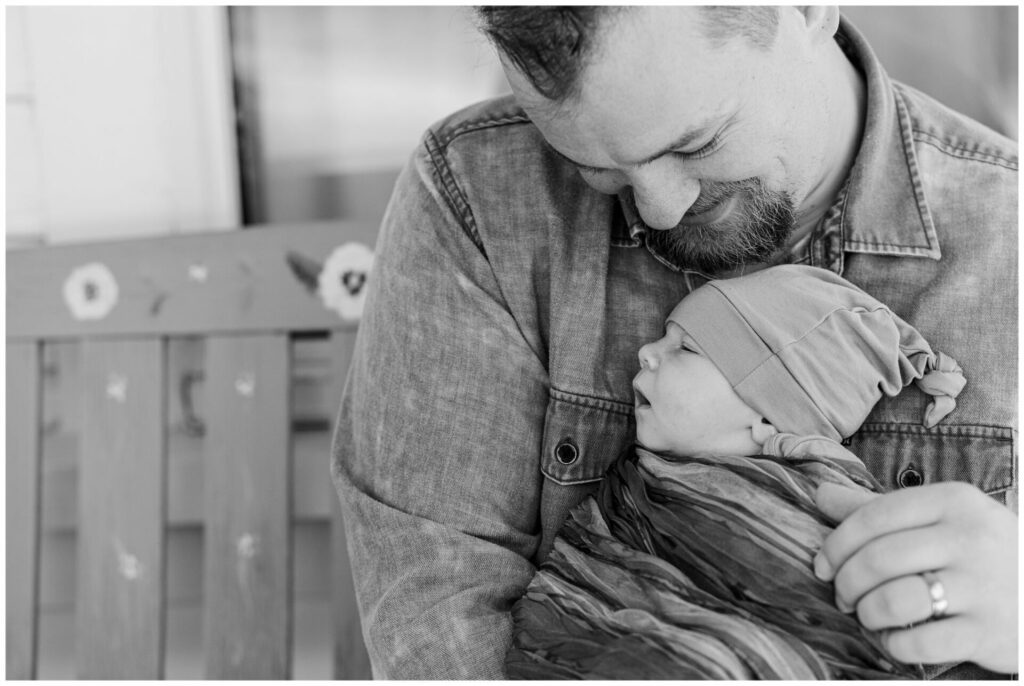 Black and white Photo of Dad holding newborn baby