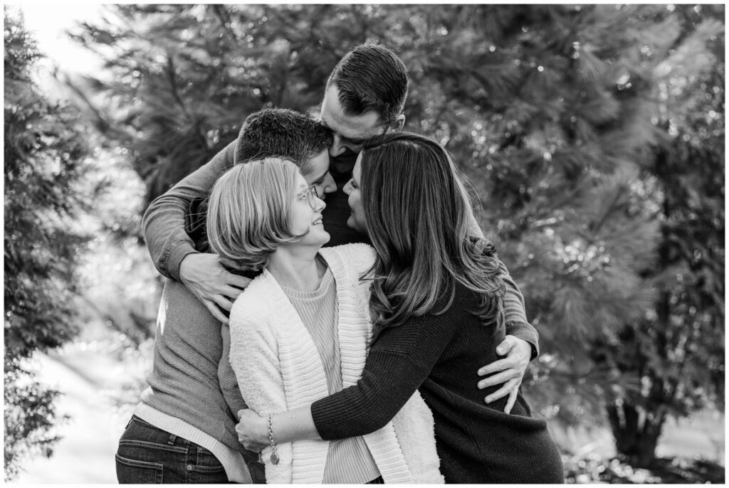 Black and white photo of family hugging during photo session Natick MA