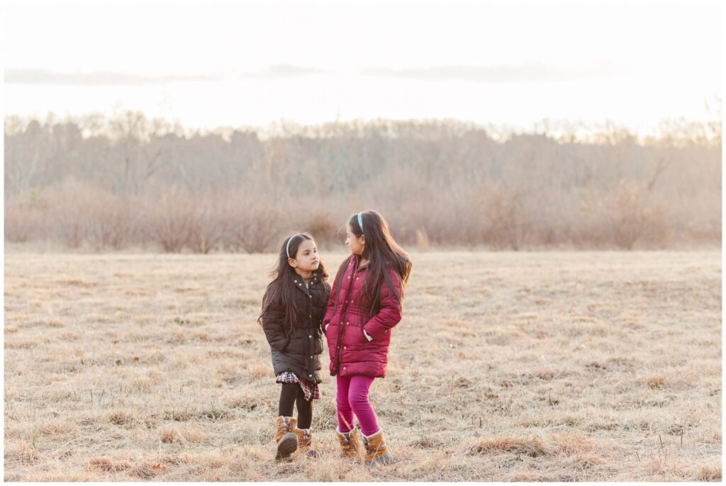 Ashland Massachusetts sisters walk in field during winter photo session 