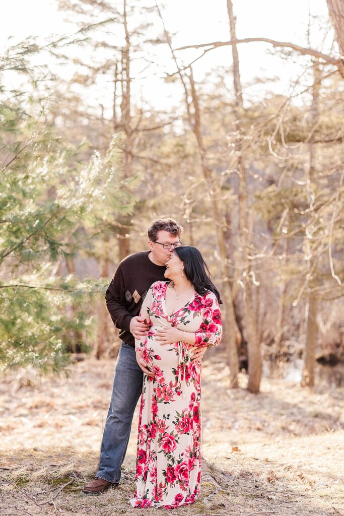 husband kisses wife's head during maternity photo session in Natick Massachusetts