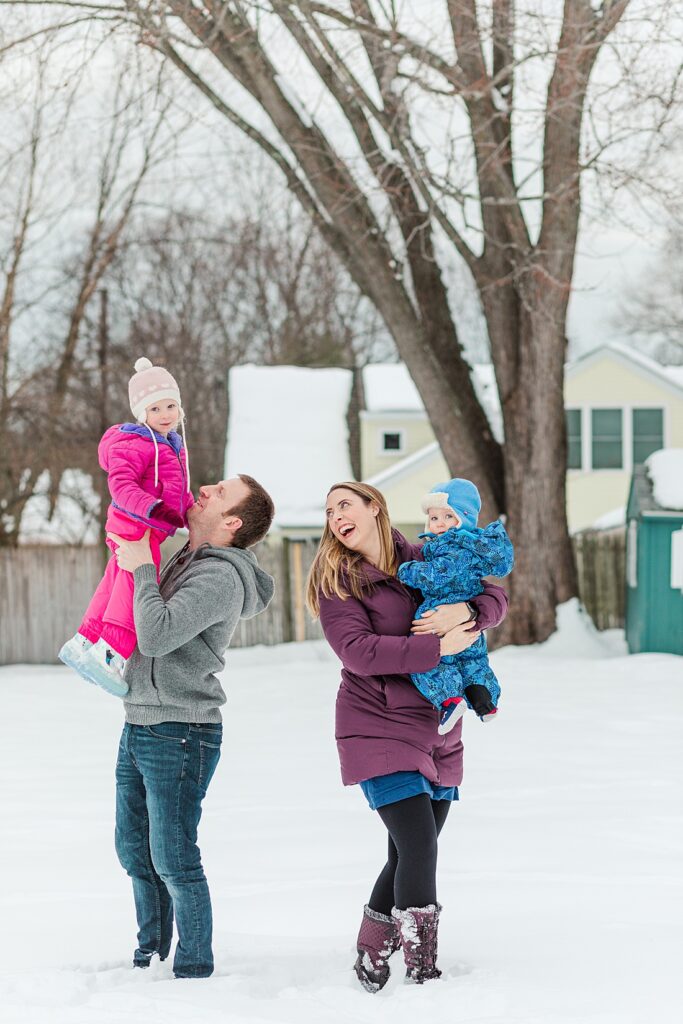 Family plays in snow for family photo in Natick Massachusetts