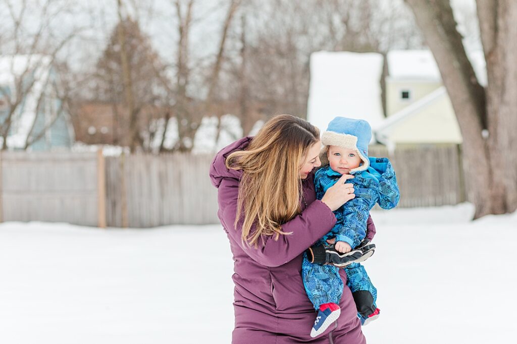 Mom holds son in the snow during family photo session for NICU blog in Natick Massachusetts