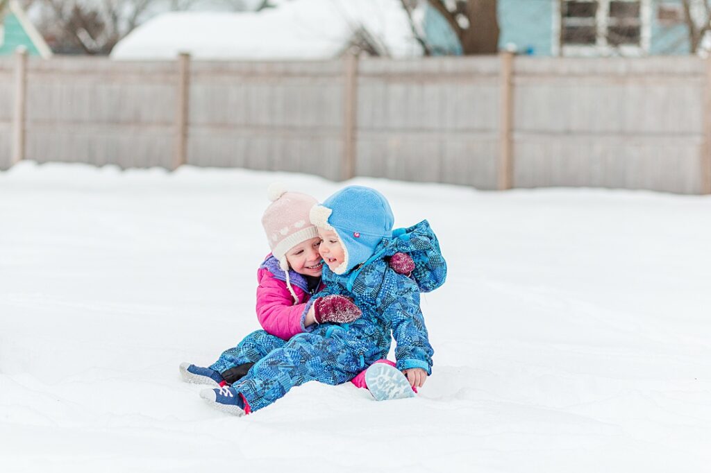 brother and sister play together in snow for family photographer in Natick Massachusetts