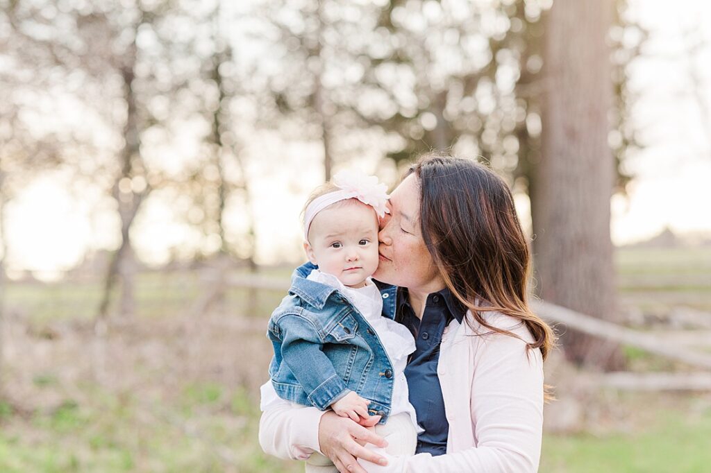 Mom kisses baby daughter's cheek during family photo session for NICU blog with Sara Sniderman Photography at Barber Reservation, Sherborn Massachusetts