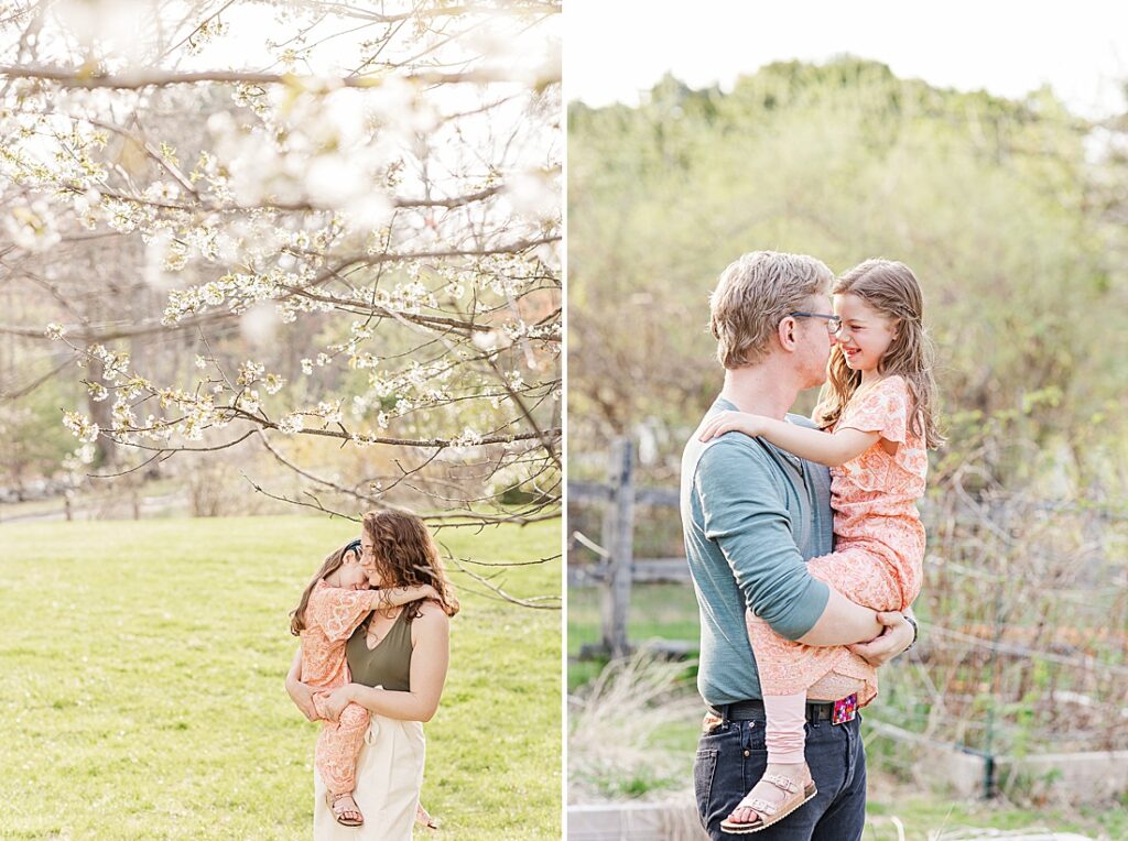 Mom holds daughter under blooming tree and dad holds daughter and rubs noses with her during family photo session with Sara Sniderman Photography in Sherborn Massachusetts