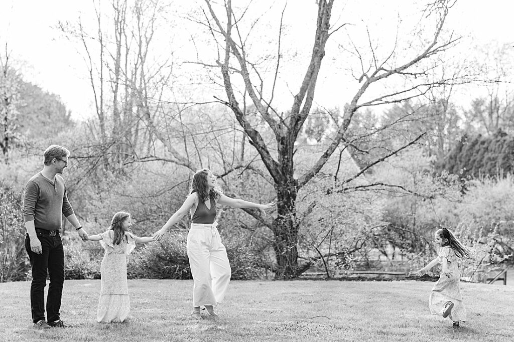 black and white photo of family dancing together during family photo session with Sara Sniderman Photography in Sherborn Massachusetts