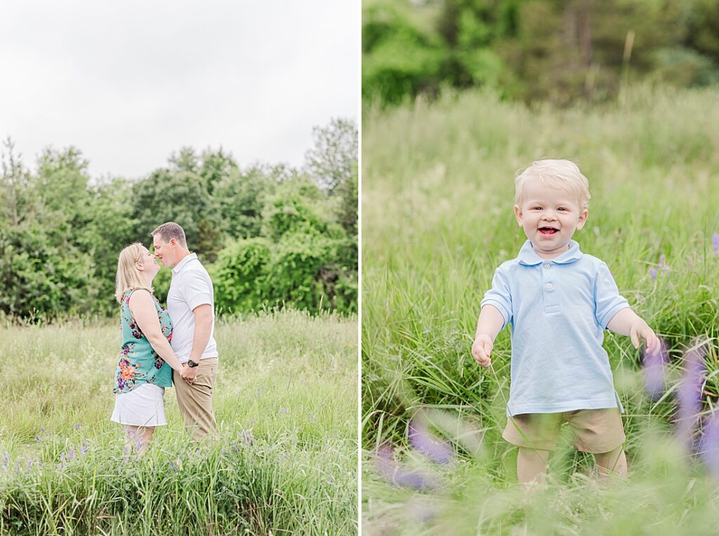 parents kiss and one year old smiles in field during full family photo session with Sara Sniderman Photography at Oak Grove Park, Millis Massachusetts