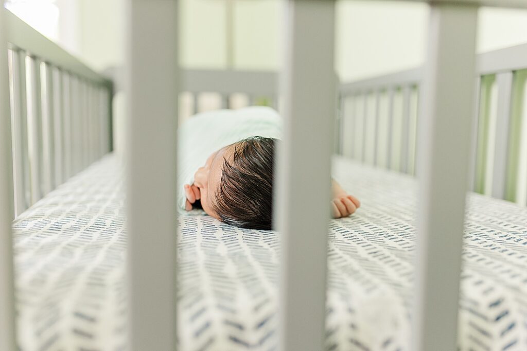 newborn sleeps in crib during in home newborn photo session with Sara Sniderman Photography in Holliston Massachusetts