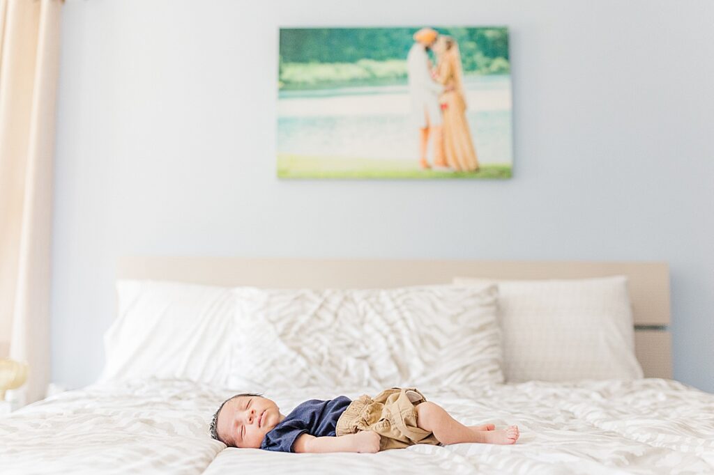 baby sleeps on parents bed during in home newborn photo session with Sara Sniderman Photography in Holliston Massachusetts