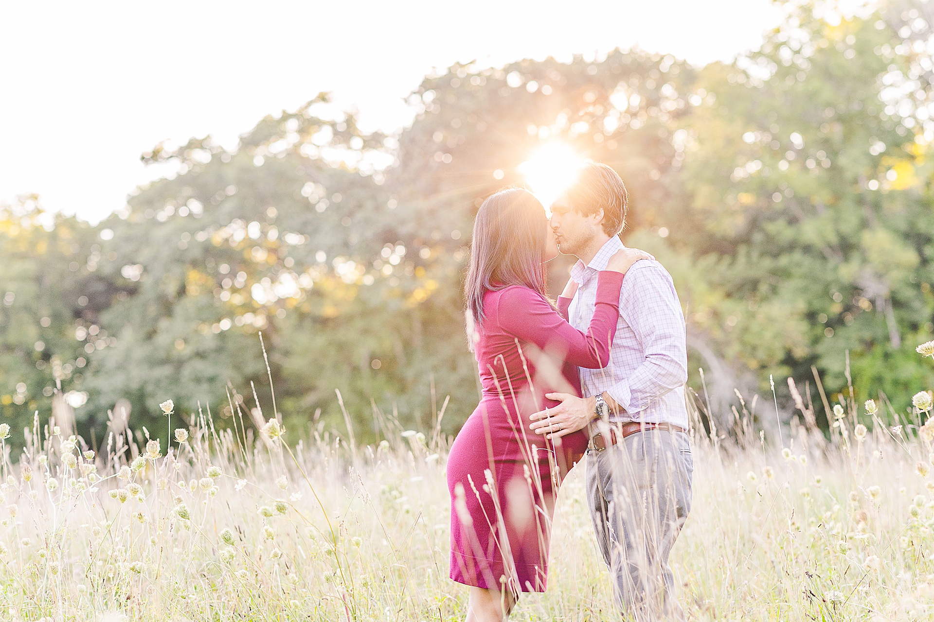 couple kisses with sun flare behind their heads during Maternity Photo Session with Sara Sniderman Photography at Head Farm in Wayland Massachusetts