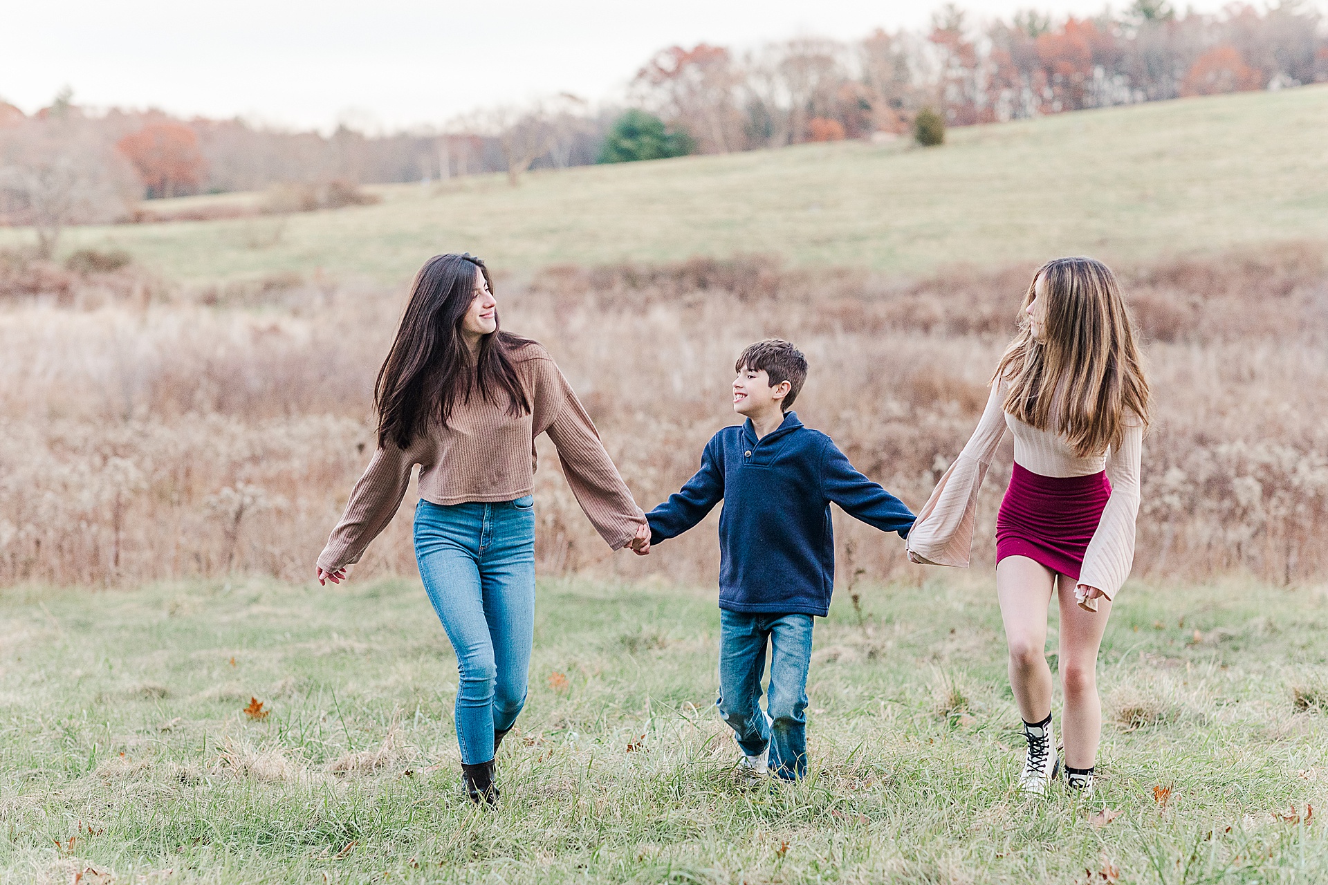 siblings holds hands and walk during extended family photo session with Sara Sniderman Photography at Breakneck HIll Reservation, Southboro Massachusetts
