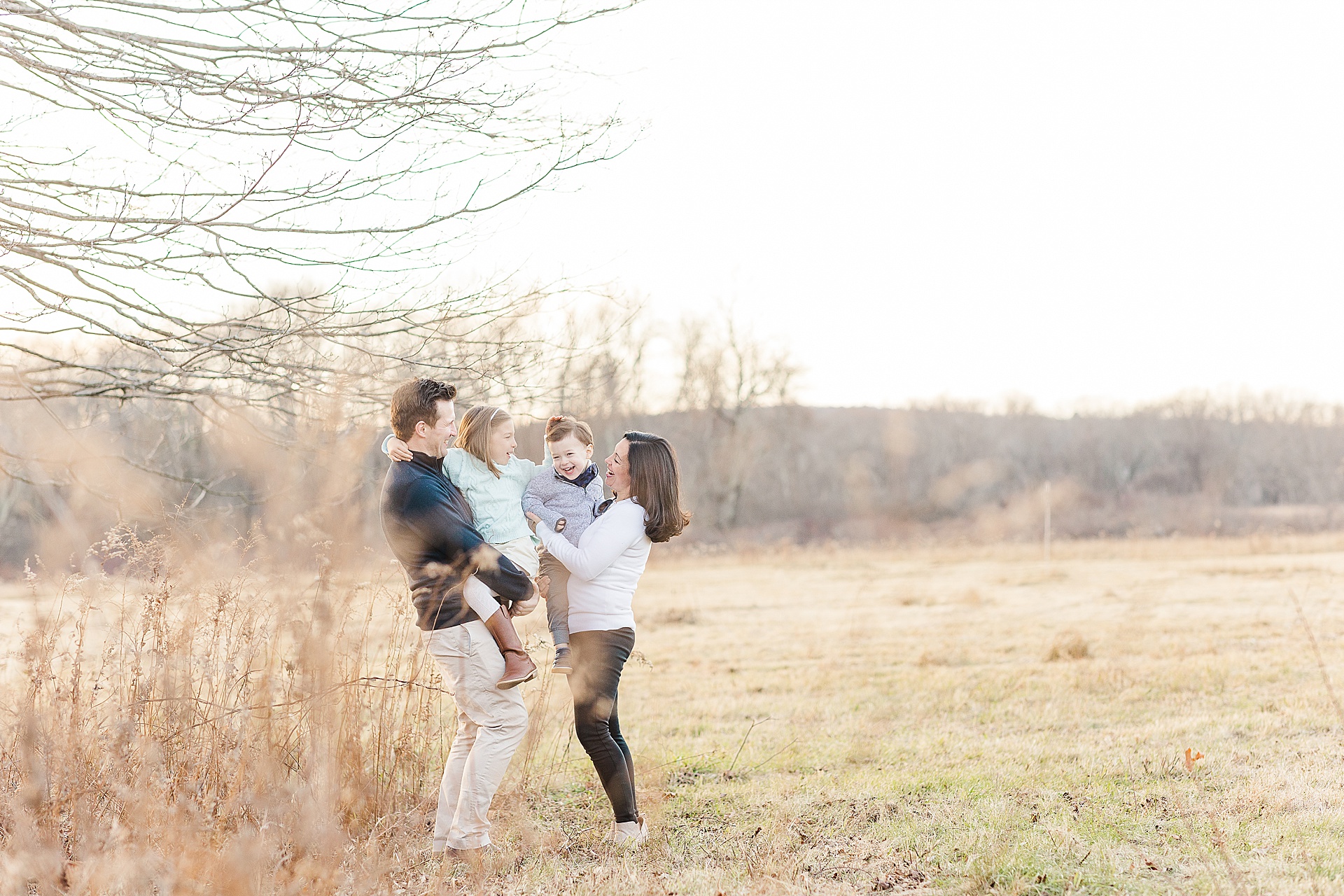 family cuddles during photo session with Sara Sniderman Photography at Cow Common, Wayland Massachusetts
