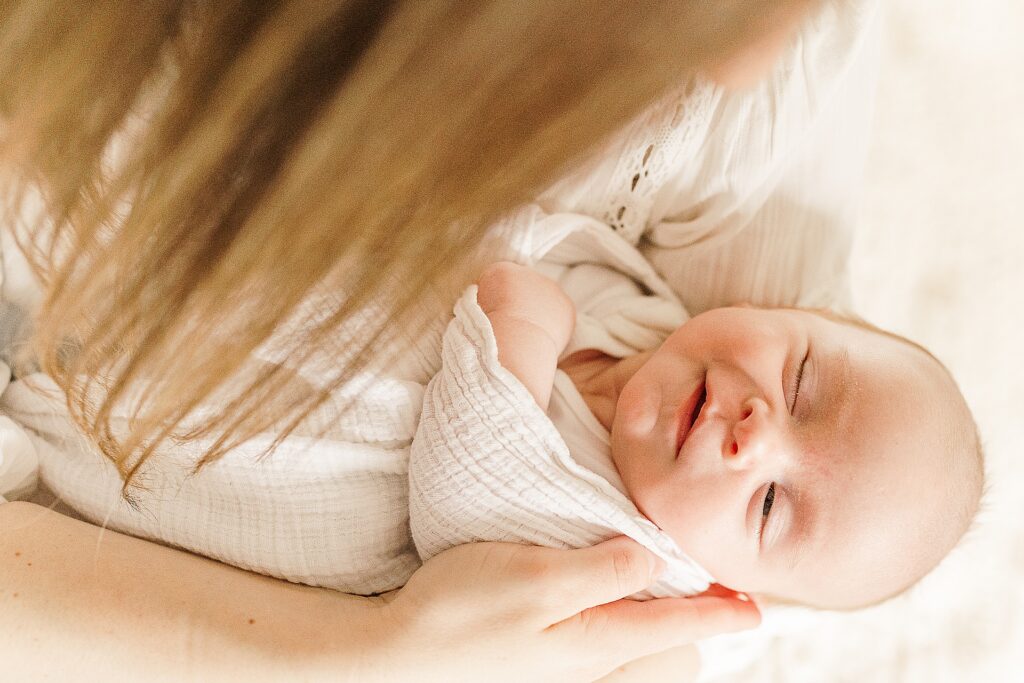 baby smiles while sleeping during in home photo session with one month old baby with Sara Sniderman Photography Natick Massachusetts