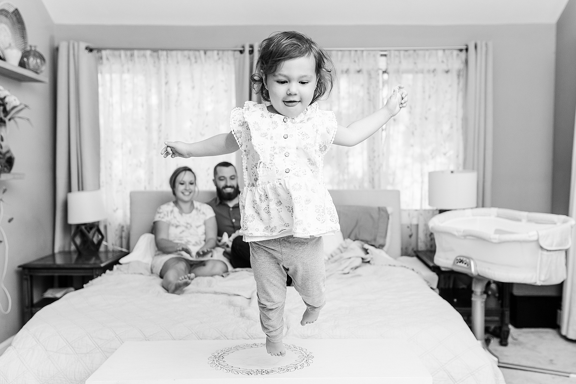 black and white photo of toddler jumping off a bed during in home photo session with Sara Sniderman Photography in Natick Massachusetts