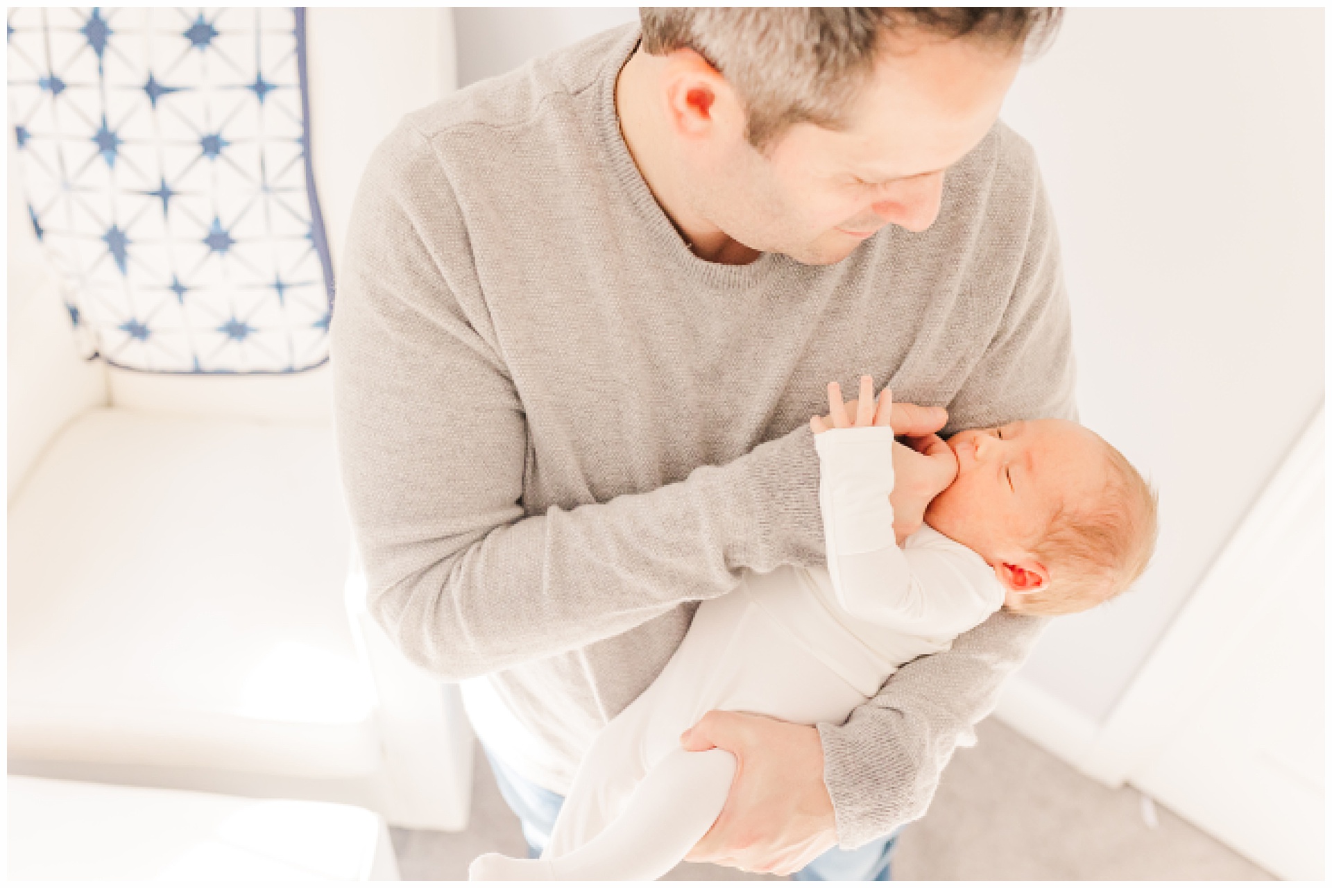 father holds son during in home newborn photo session with Sara Sniderman Photography in Sherborn Massachusetts