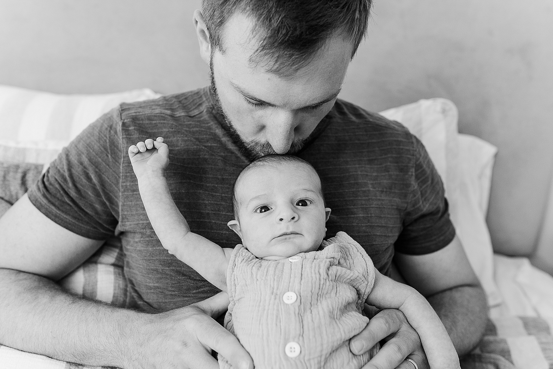 black and white of father kissing baby during in home newborn photo session with Sara Sniderman Photography Southborough Massachusetts
