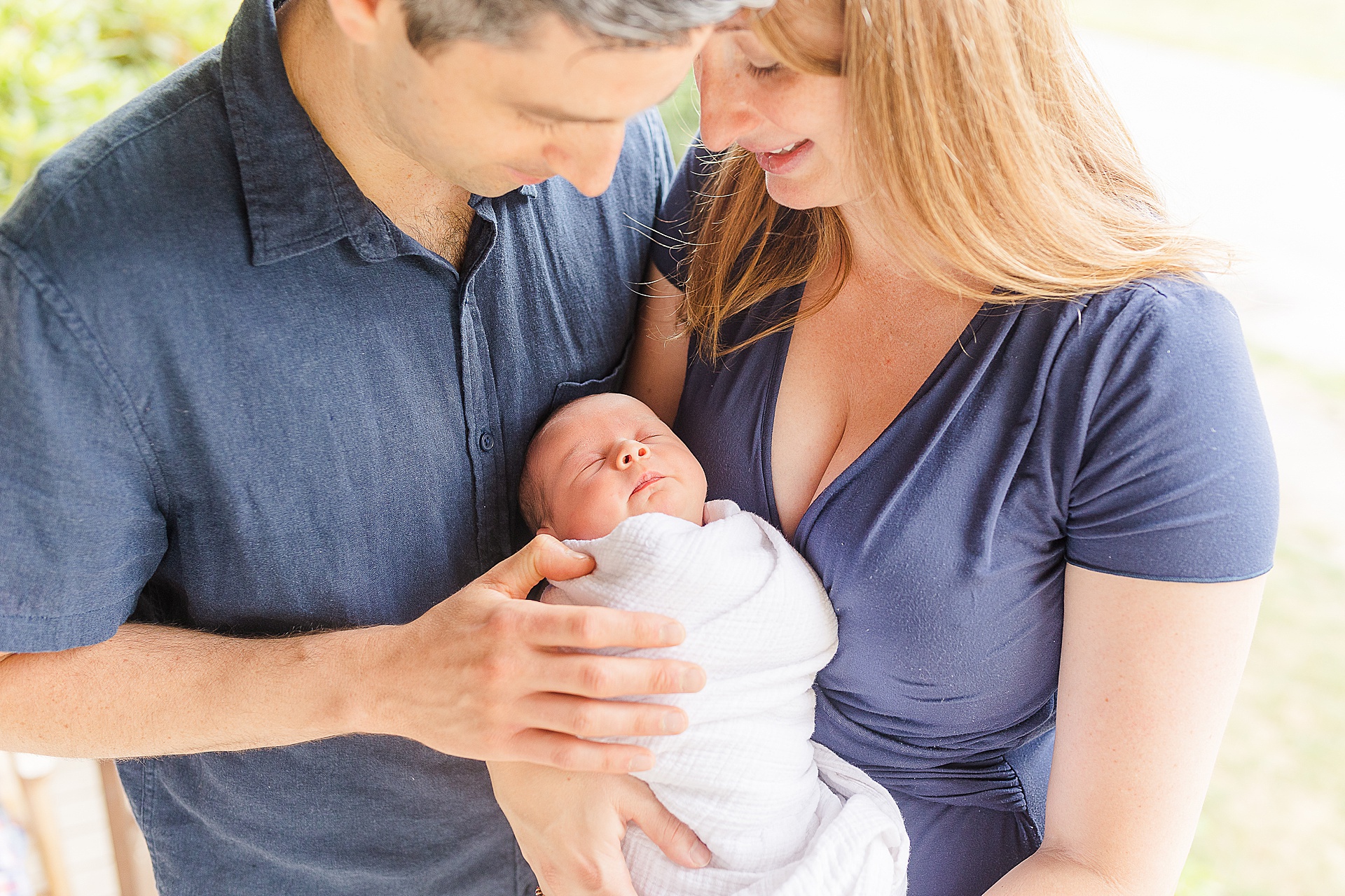 parents hold baby during in home newborn photo session with Sara Sniderman Photography in Ashland Massachusetts