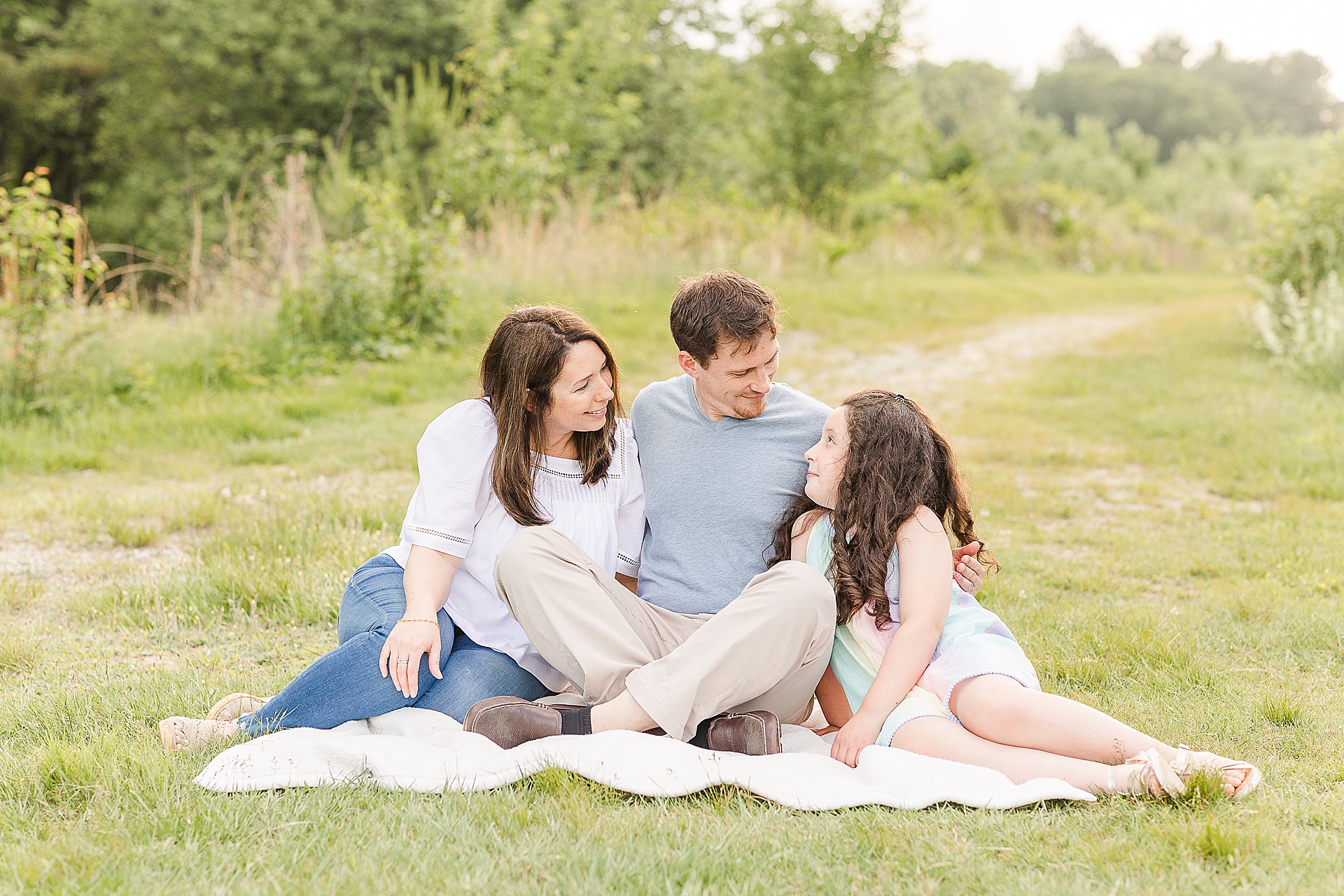 family sits on blanket during family photo session with Sara Sniderman Photography at Breakneck Hill Conservation Land, Southborough Massachusetts
