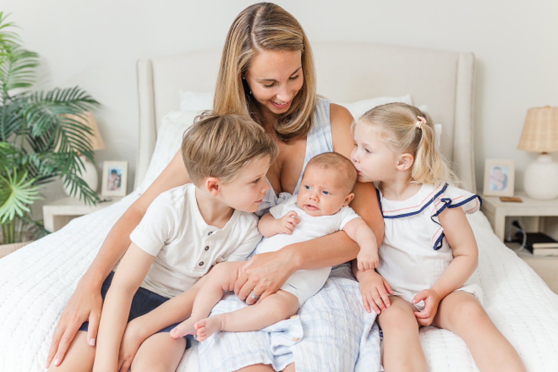 Mom holds her three children during in home baby photo session with Sara Sniderman Photography in Wellesley Massachusetts