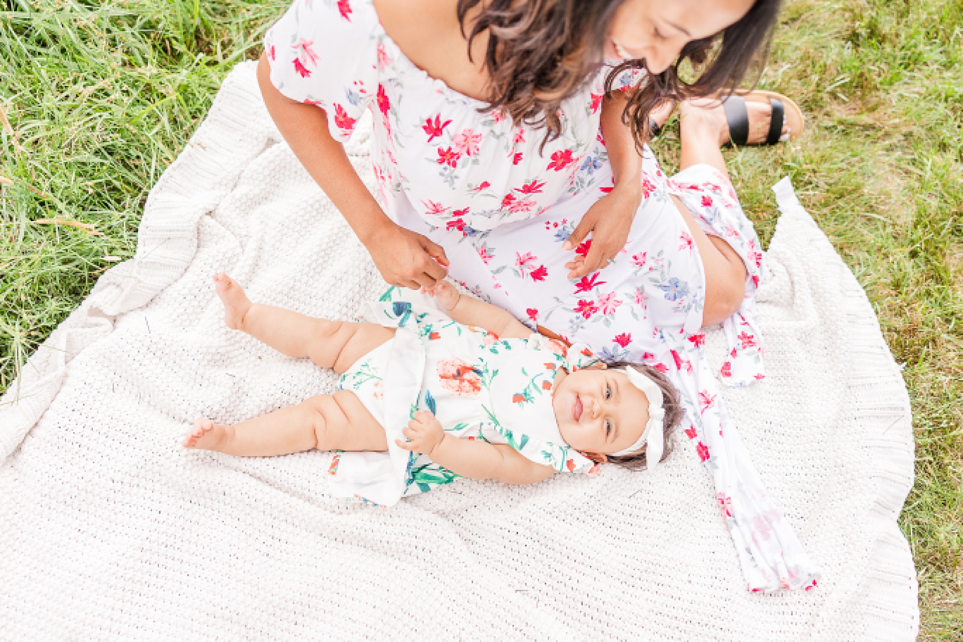 baby lays on blanket with mom during family photo session with Sara Sniderman Photography at heard farm in Wayland Massachusetts.