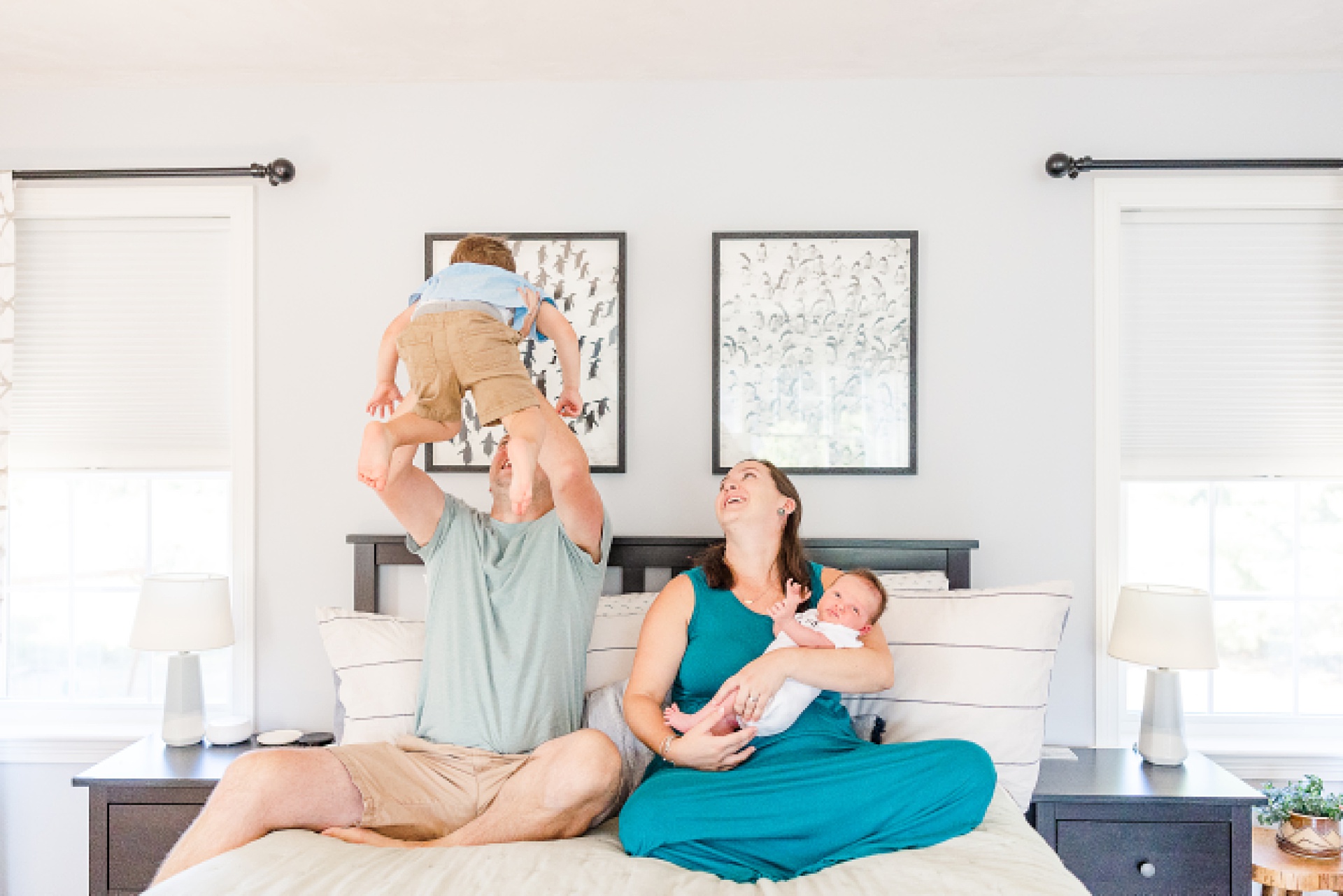family plays on bed during in home newborn session with Sara Sniderman Photography in Medway Massachusetts