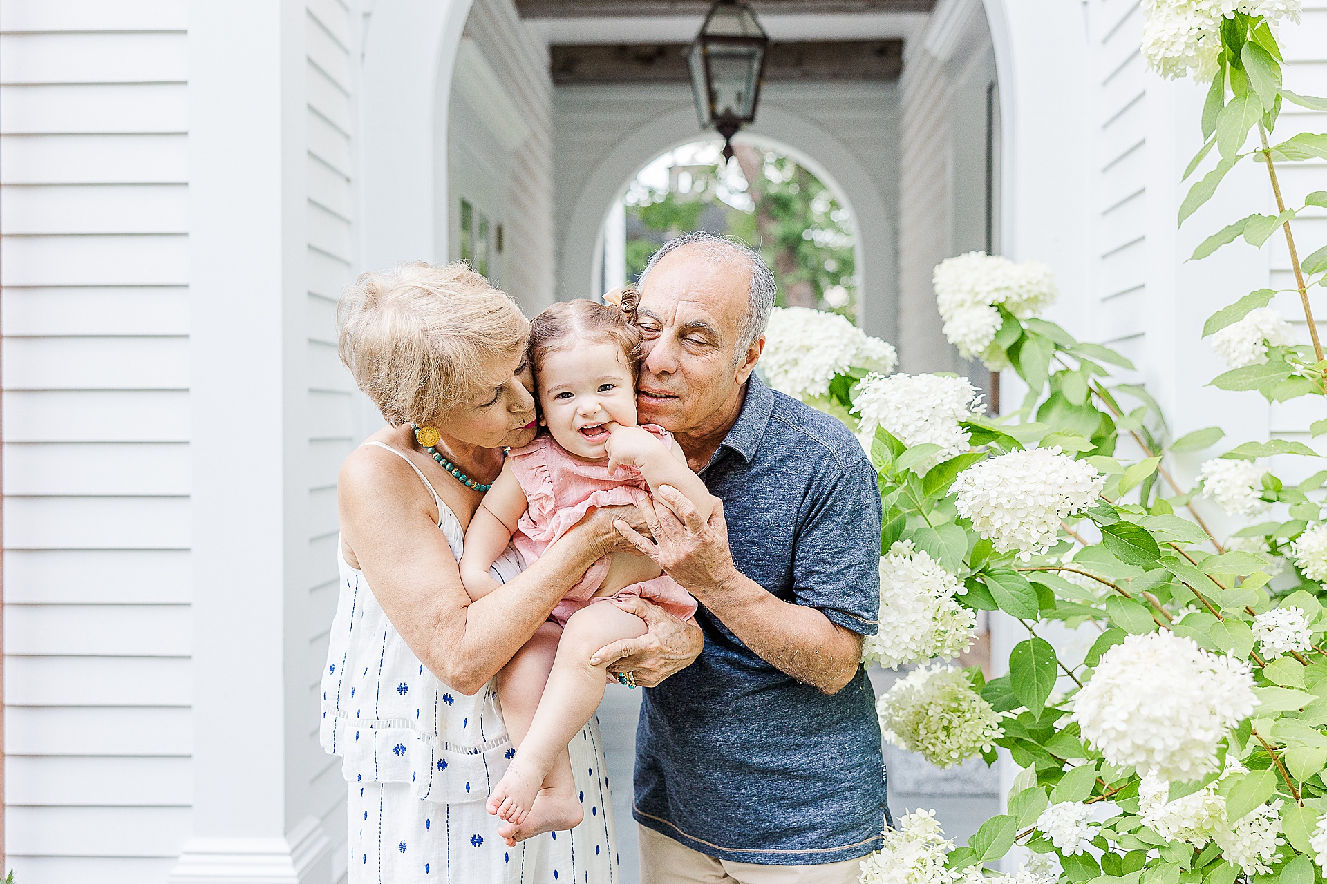 grandparents kiss granddaughter during family photo session with Sara Sniderman Photography in Newton Massachusetts