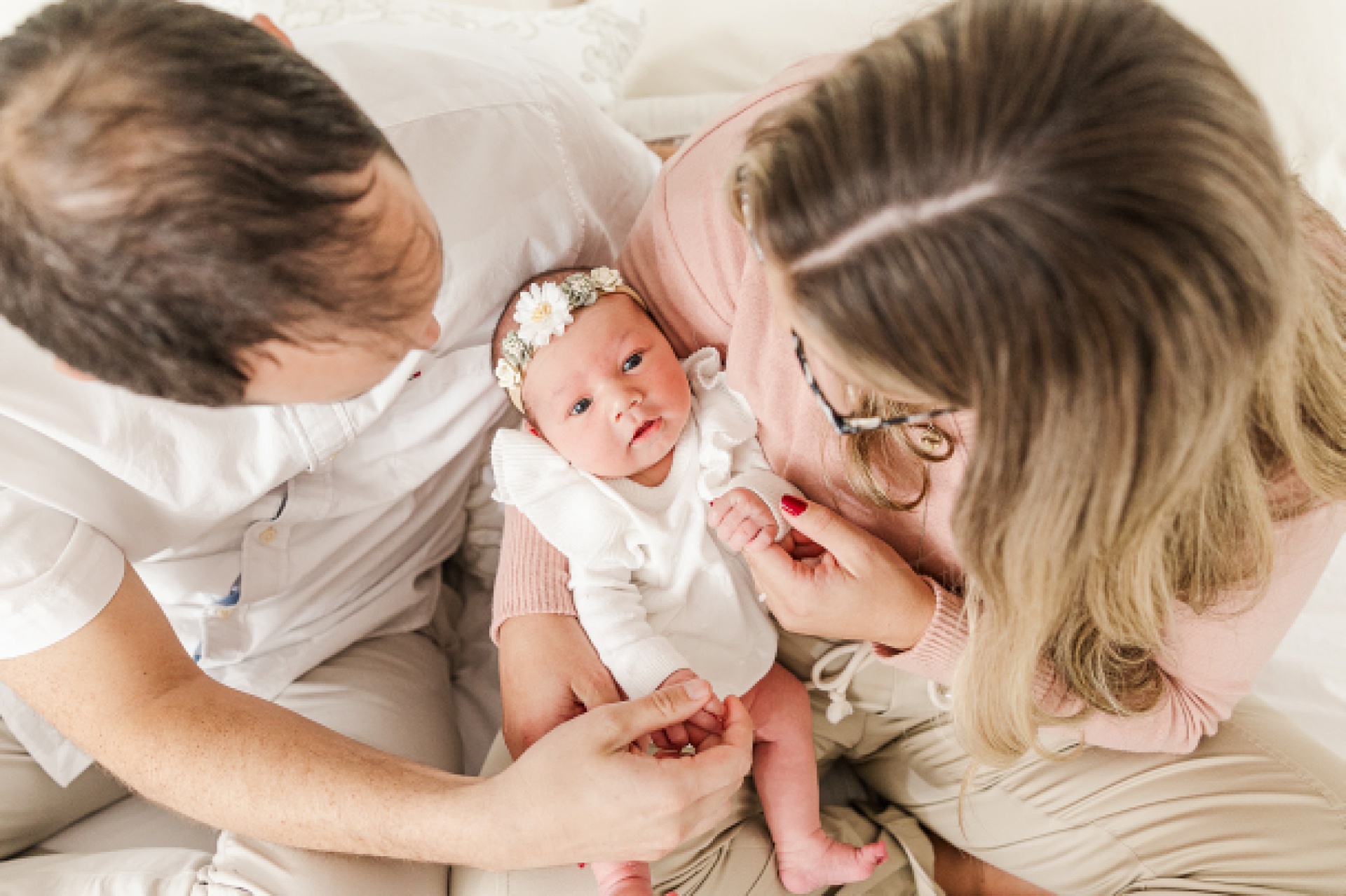 parents hold baby during in home newborn photo session with Sara Sniderman Photography in Natick Massachusetts