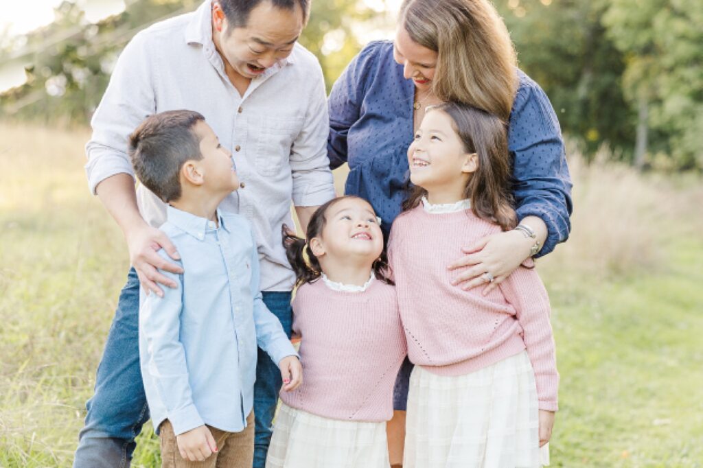 family laughs together during family photo session of the momming worker in Needham Massachusetts with Sara Sniderman Photography
