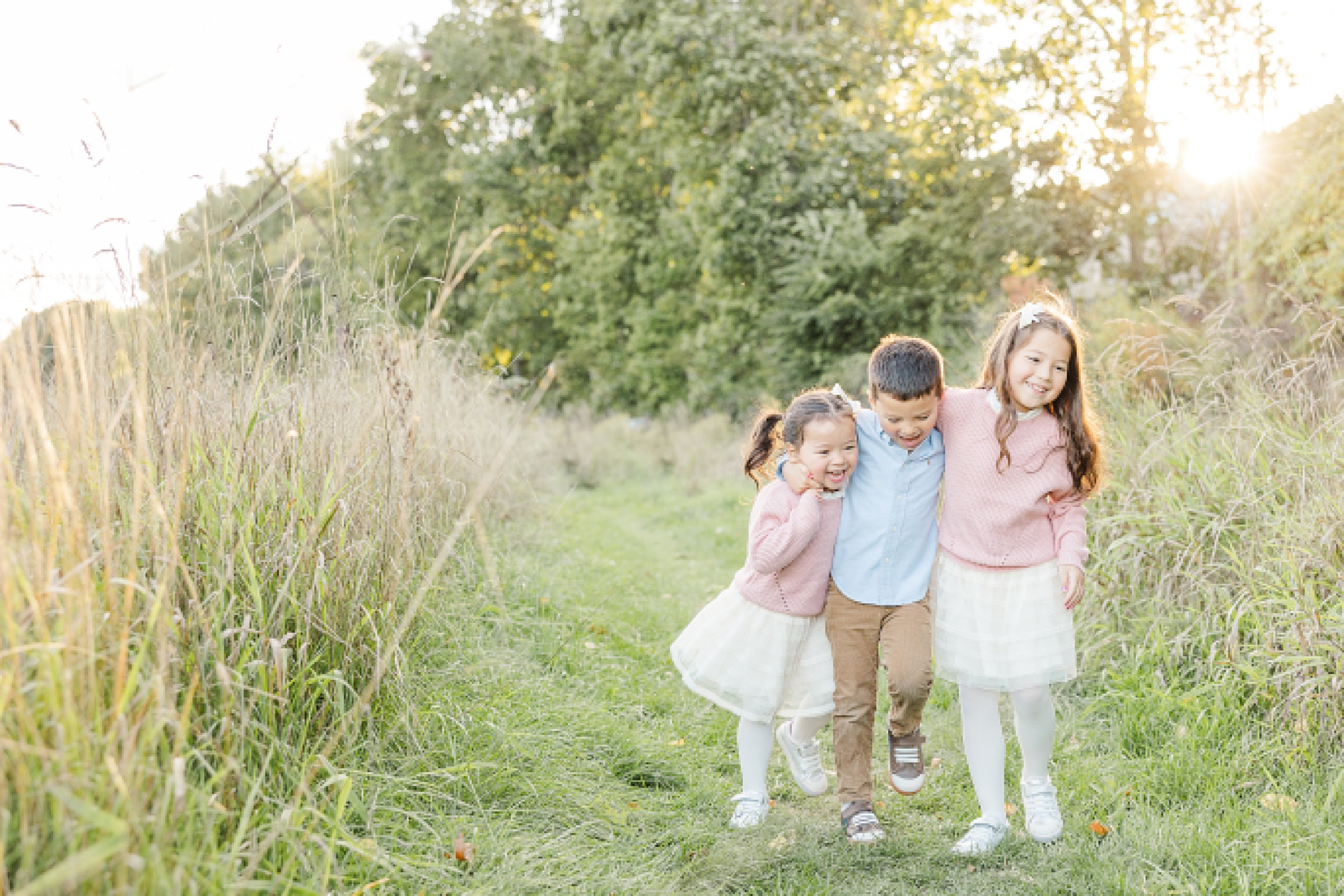 siblings walk and laugh during family photo session of the momming worker in Needham Massachusetts with Sara Sniderman Photography