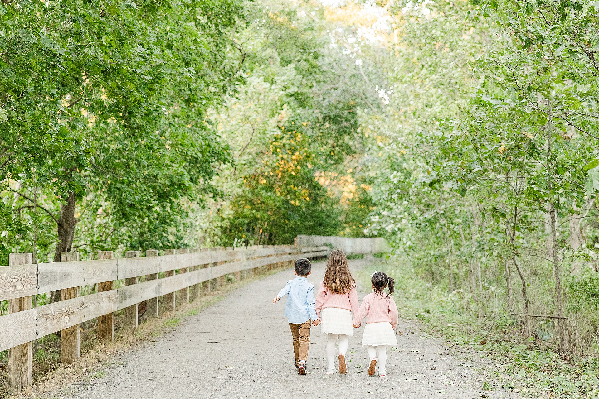 siblings walk holding hands during family photo session of the momming worker in Needham Massachusetts with Sara Sniderman Photography