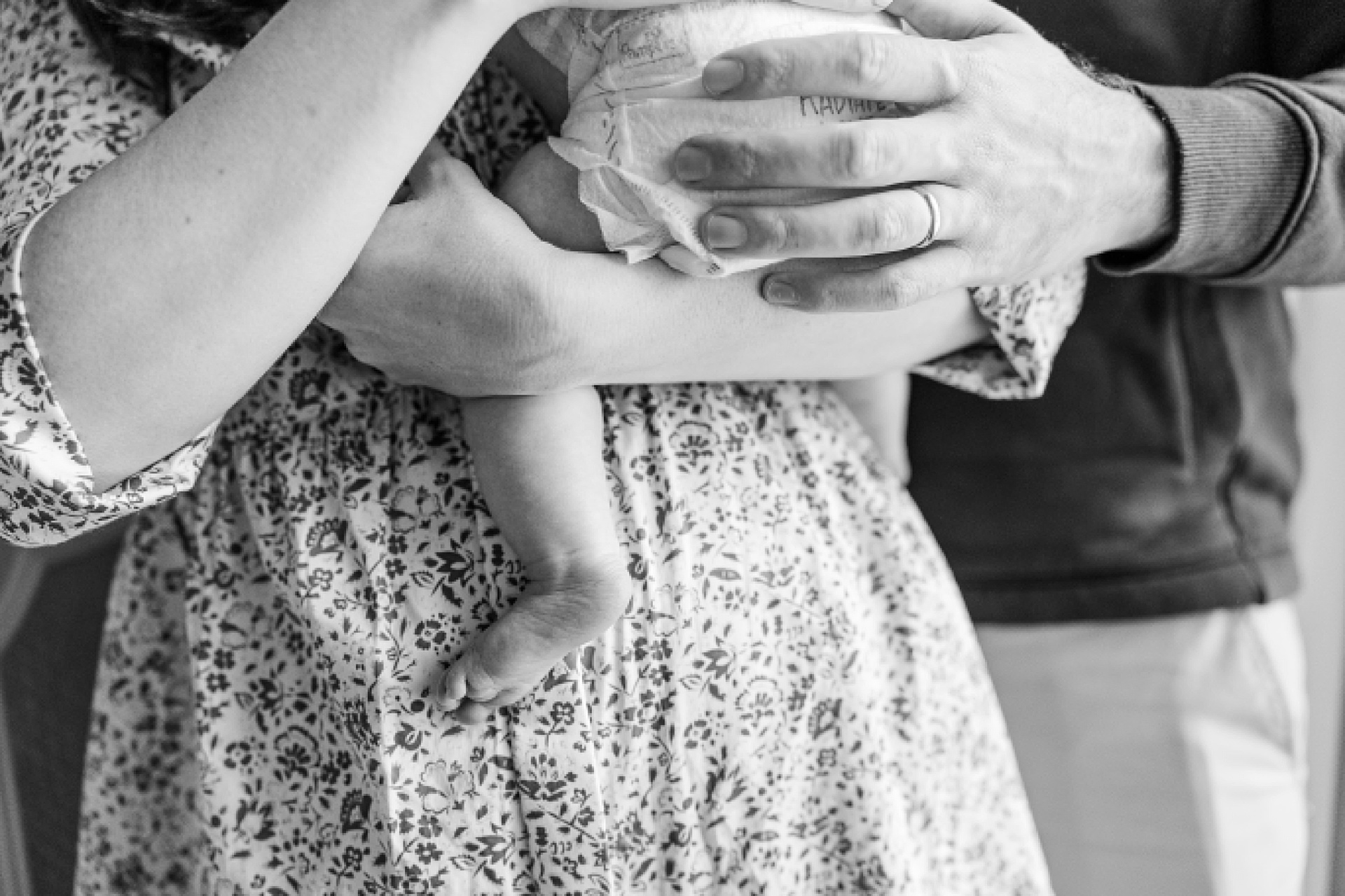 black and white photo of baby feet while mom holds baby during in home newborn photo session with Sara Sniderman Photography in Natick Massachusetts