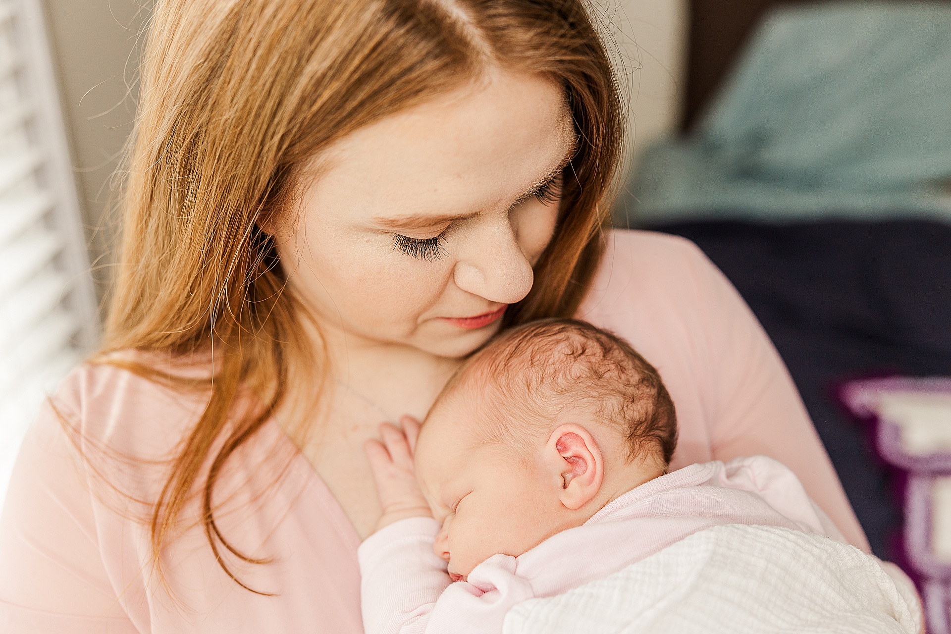 mom holds baby during in home newborn photo session with Sara Sniderman Photography in Wellesley Massachusetts