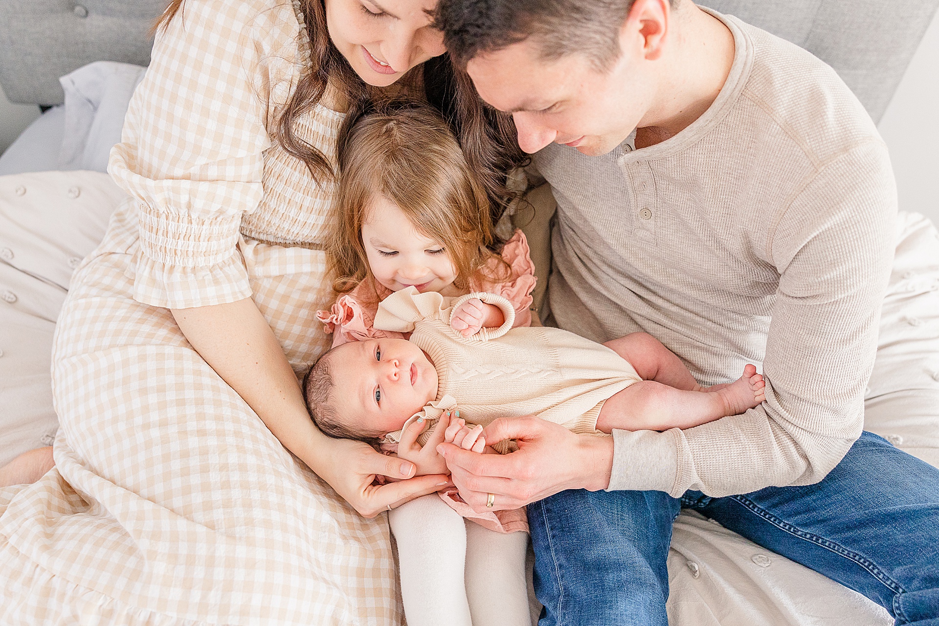 family cuddles on bed during in home photo session in Medway Massachusetts with Sara Sniderman Photography
