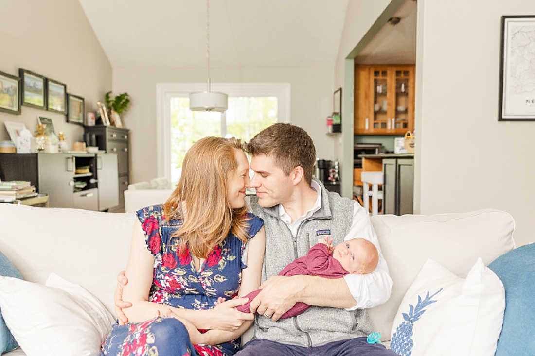 parent sit on couch during Lifestyle newborn photo session in Needham Massachusetts with Sara Sniderman Photography