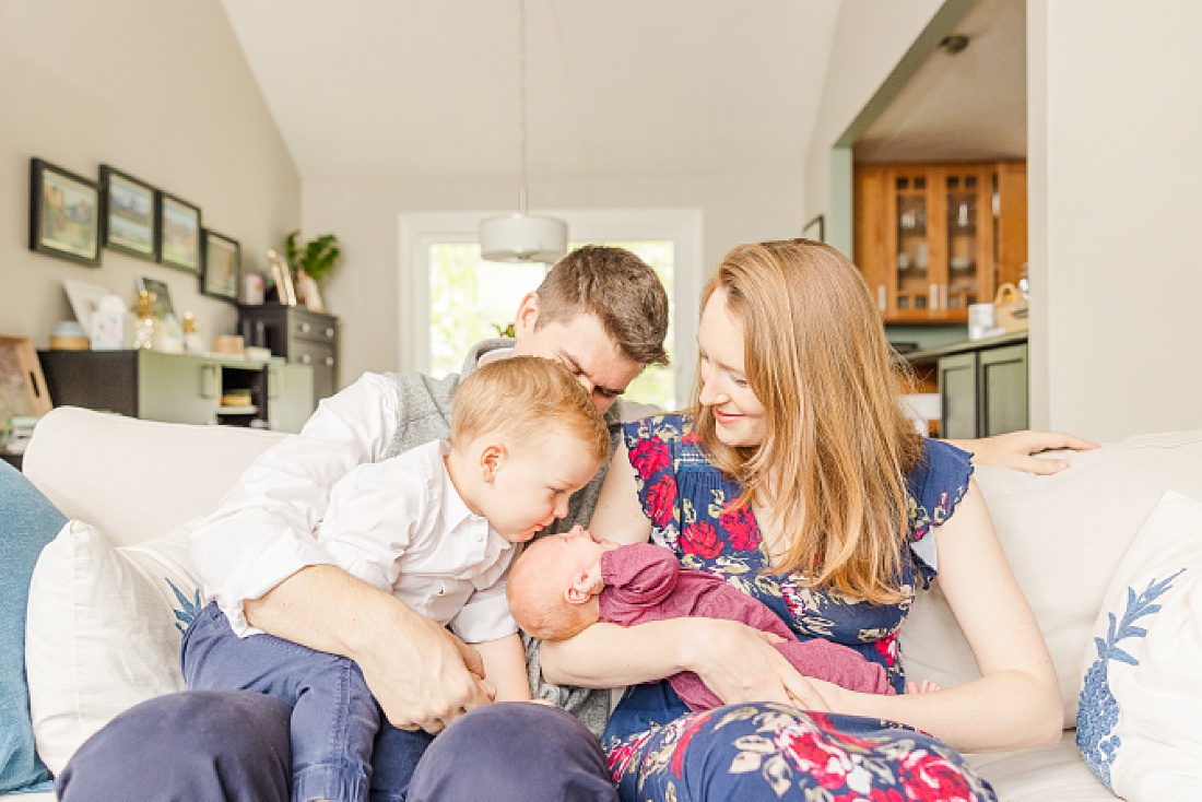 family snuggles on couch during Lifestyle newborn photo session in Needham Massachusetts with Sara Sniderman Photography