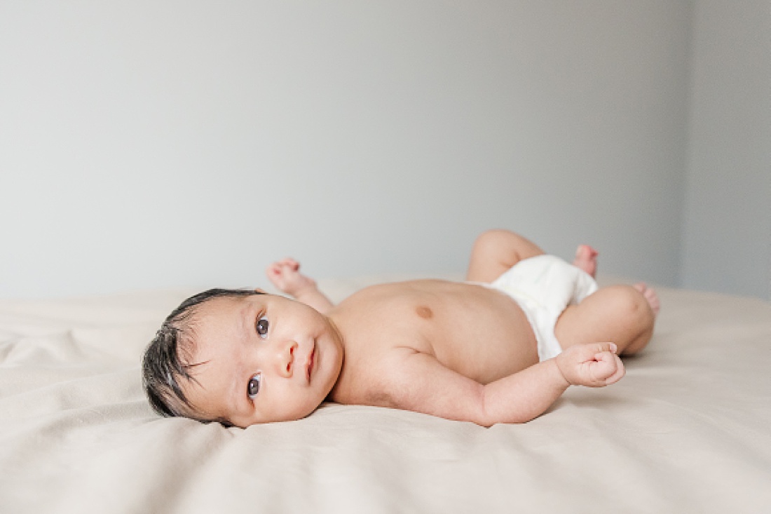baby on bed during in home newborn photography in Natick Massachusetts with Sara Sniderman Photography